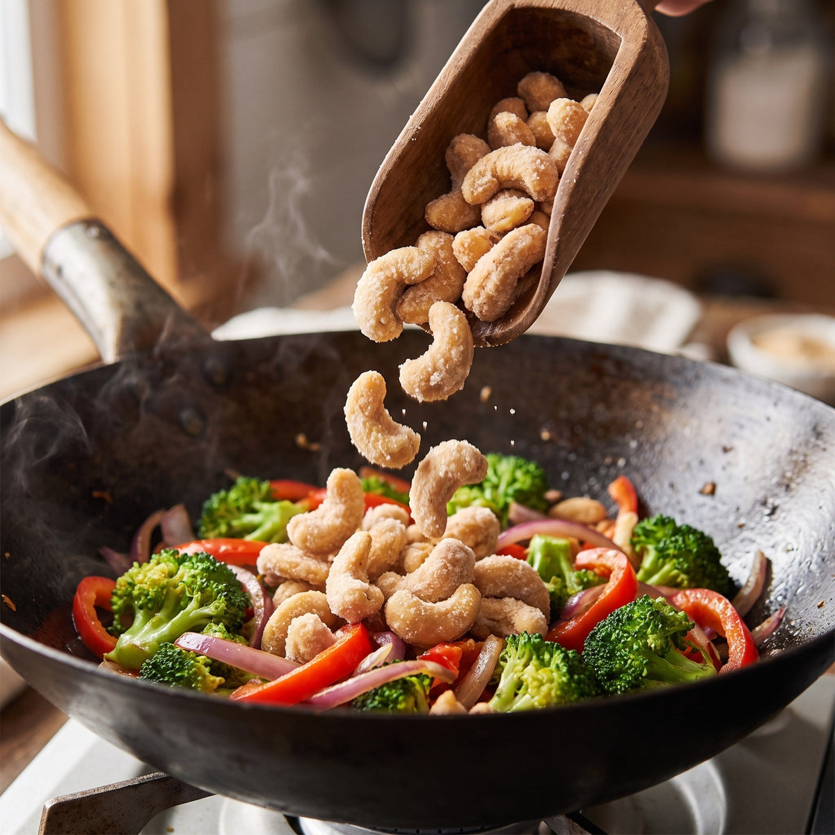 Cajous au sucre d'érable versés d'une pelle en bois dans un wok fumant de brocolis et poivrons rouges