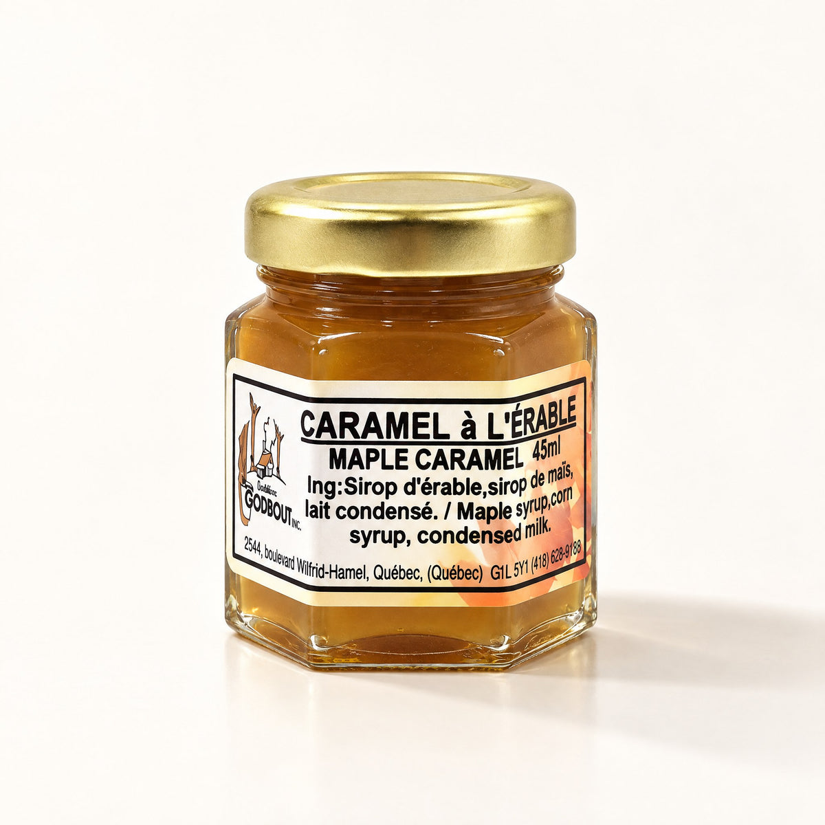Petit pot hexagonal de caramel à l'érable au couvercle doré, posé sur un fond crème épuré avec ombre douce