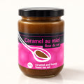 Pot de caramel au miel et fleur de sel au couvercle noir, posé sur un fond crème épuré et lumineux