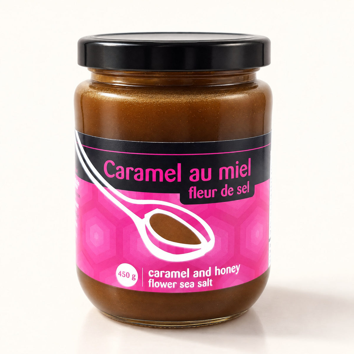 Pot de caramel au miel et fleur de sel au couvercle noir, posé sur un fond crème épuré et lumineux