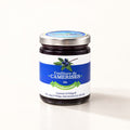 Un pot en verre de confiture de camerises à la cardamome, présenté sur un fond crème neutre