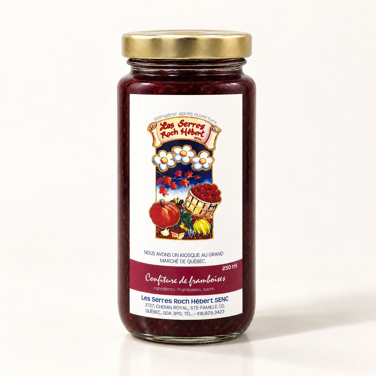 Un pot en verre de confiture de framboises avec son couvercle doré, déposé sur un fond crème épuré