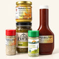 Ensemble pour le BBQ composé de cinq condiments à l'érable, sauce, moutarde, relish et épices sur fond crème