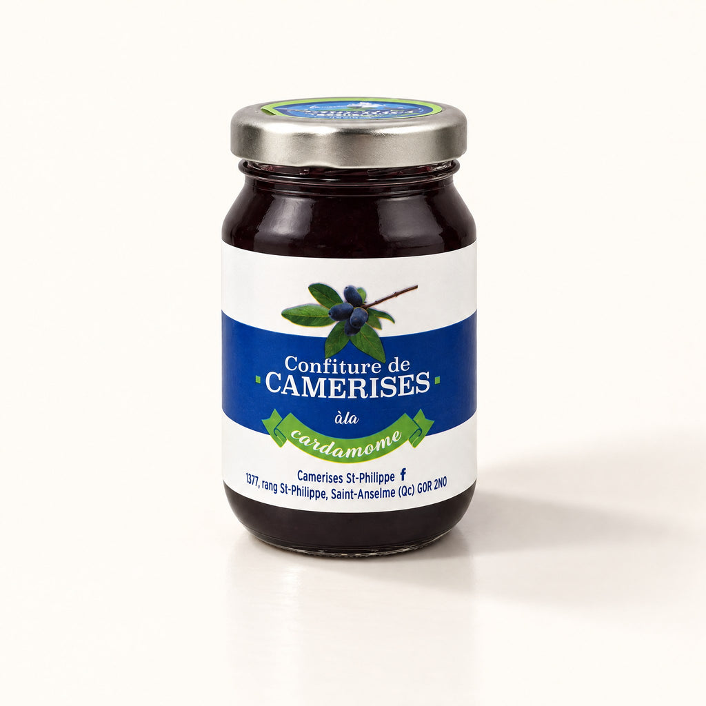 Un pot de gelée de camerises à la cardamome posé sur un fond crème épuré avec une ombre douce