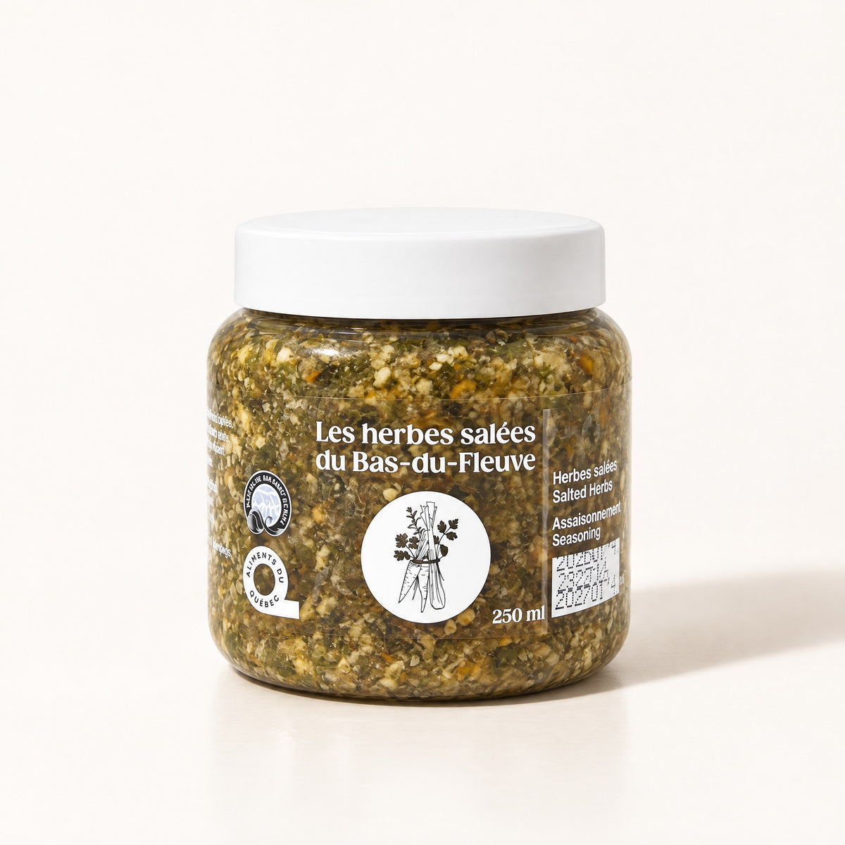 Un pot d'herbes salées du Bas-du-Fleuve avec son couvercle blanc sur un fond crème épuré