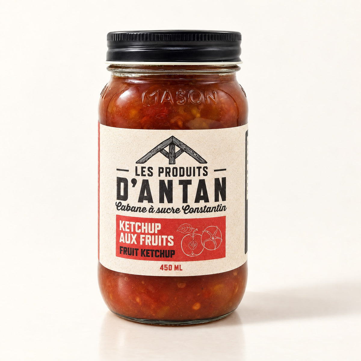 Un pot Mason de ketchup aux fruits Les Produits D'Antan sur un fond crème épuré