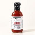 Bouteille de ketchup fumé au rhum nordique de la Mine de Ketchup, présentée sur un fond crème épuré