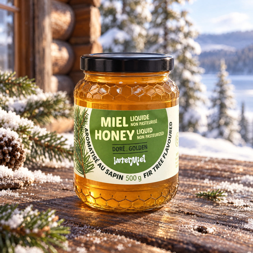 Un pot de miel aromatisé au sapin posé sur une table en bois enneigée devant un chalet et une forêt en hiver