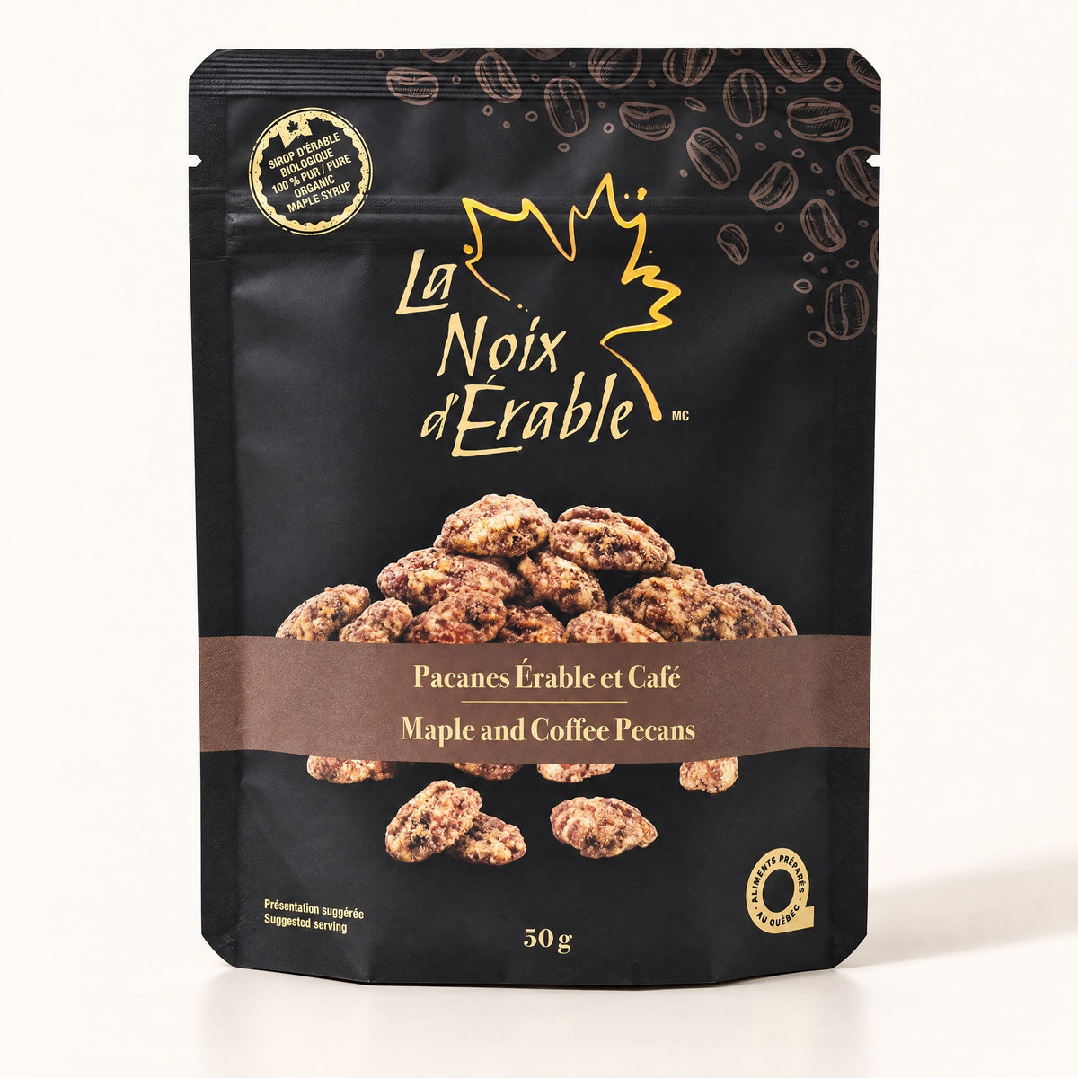 Sachet noir de pacanes érable et café de La Noix d’Érable, posé debout sur un fond crème uni