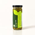 Pot de relish au miel en verre avec étiquette verte, posé seul sur un fond crème minimaliste