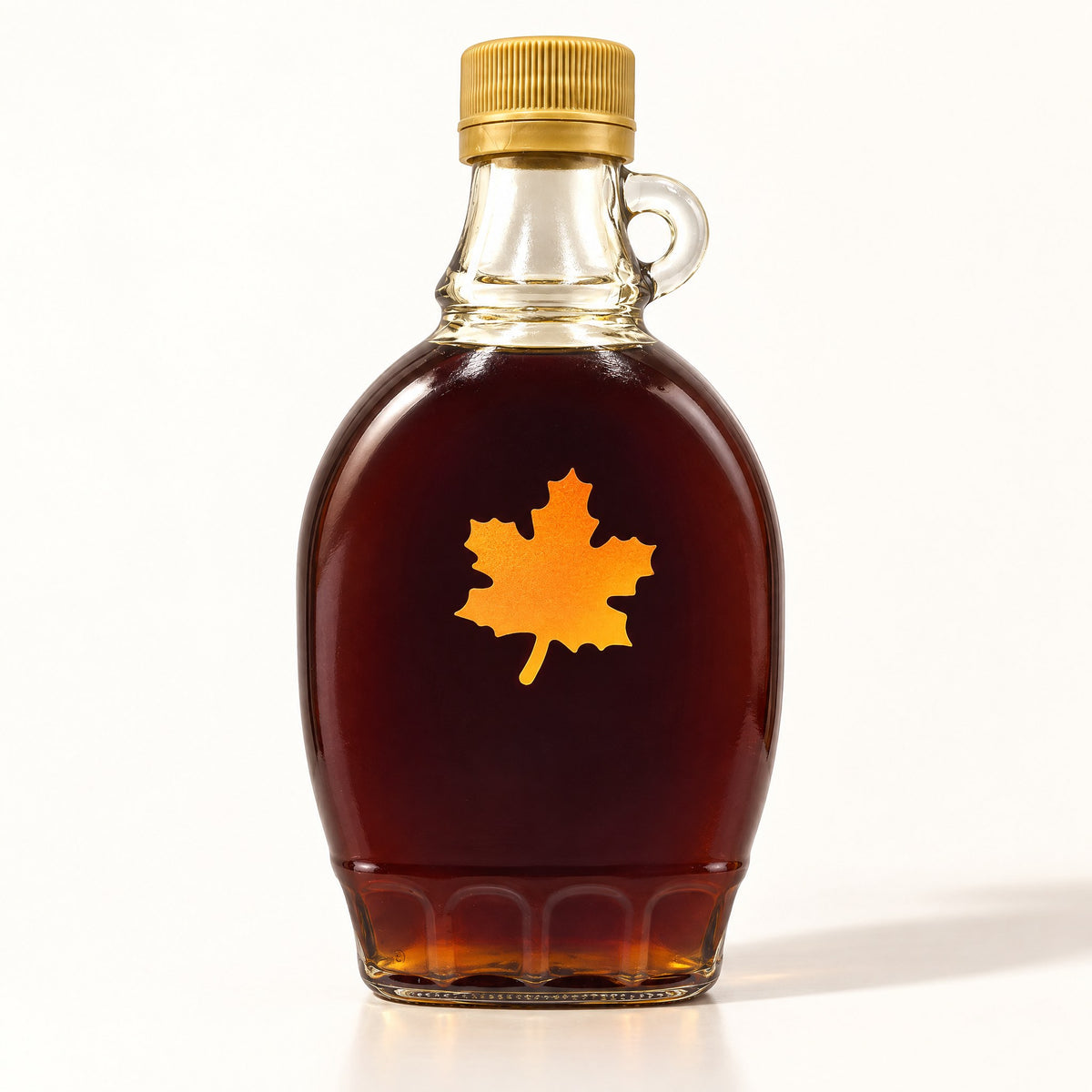 Bouteille de sirop d'érable de 250 ml en verre ambré, debout seule sur fond crème avec ombre douce
