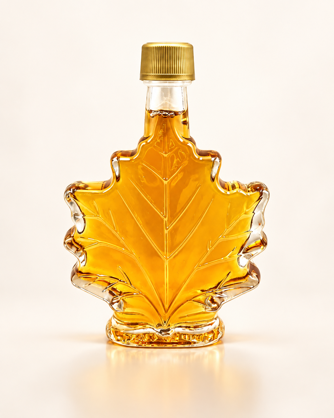 Bouteille de sirop d'érable en forme de feuille, bouchon doré, sur fond crème