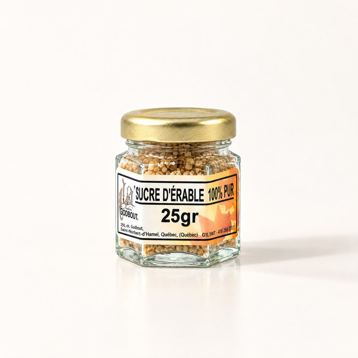Petit pot de sucre d’érable granulé de 25 g avec couvercle doré, posé seul sur fond crème
