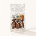 Bonbons tire éponge au chocolat au lait, emballés dans un sachet transparent sur fond crème