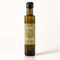 Bouteille en verre ambré de vinaigre de gadelle blanche bio, debout sur fond crème épuré