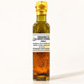 Bouteille de vinaigrette au sirop d’érable dressée seule sur fond crème, liquide ambré visible